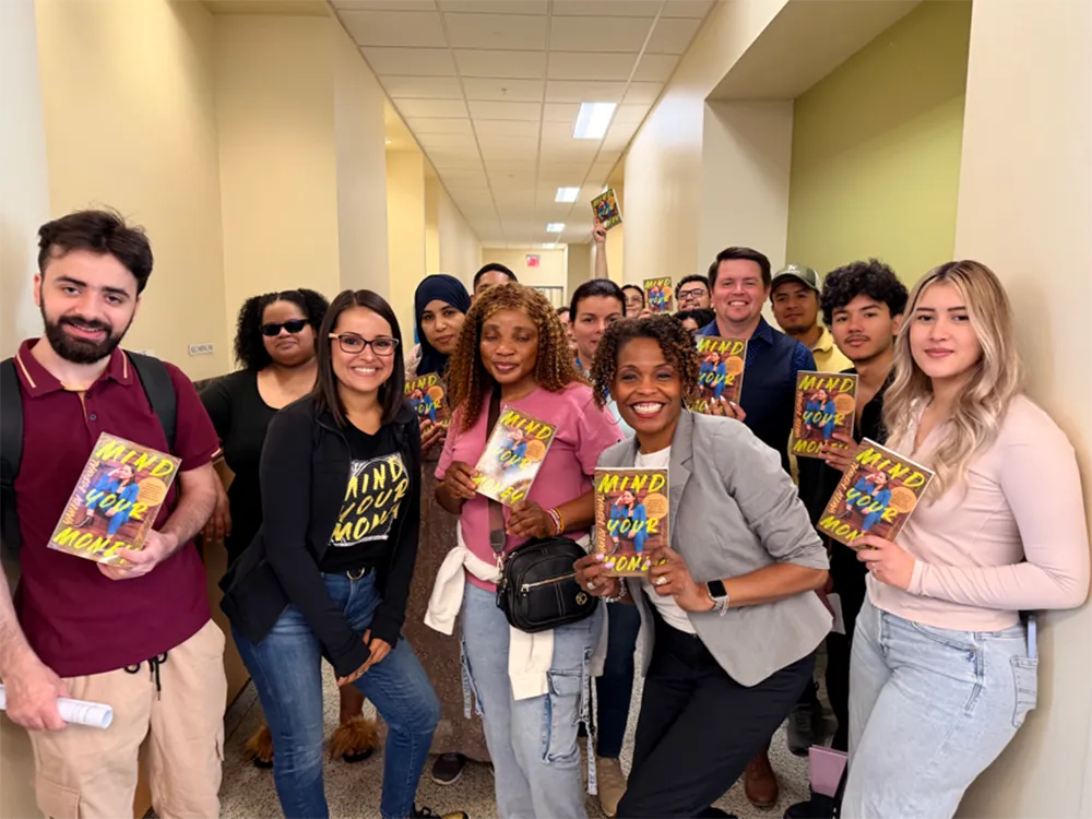 Students hold copies of a money management tips book.