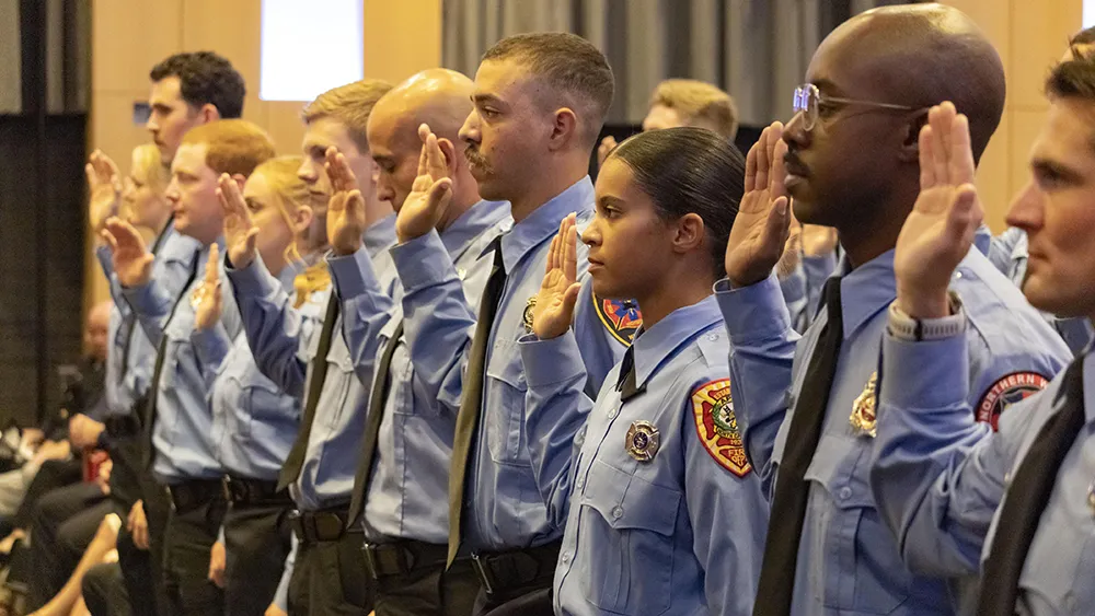 New firefighters take the oath of service at a Fire Academy graduation ceremony.