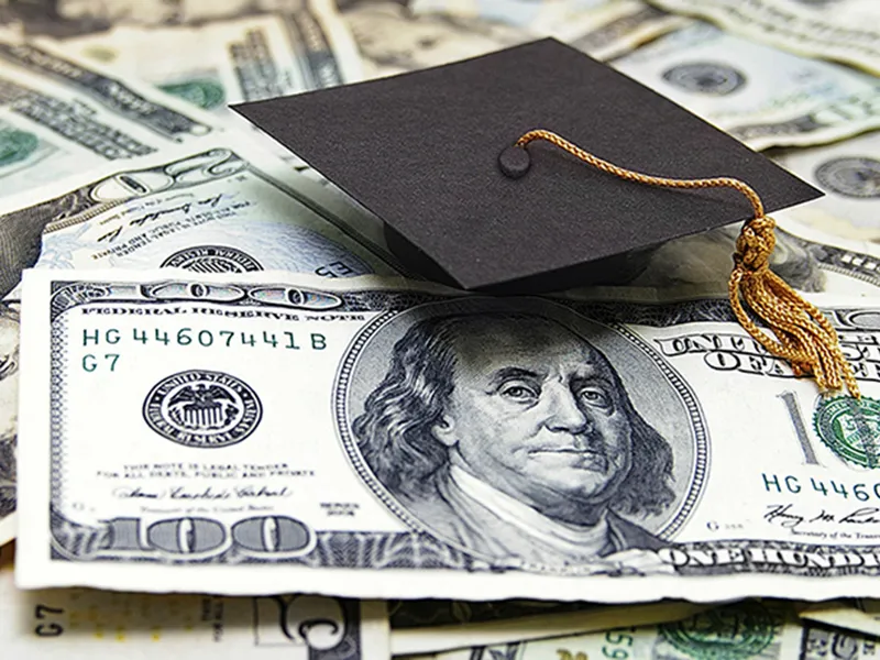 image for Financial Aid of a stack of money with a graduation cap sitting on it