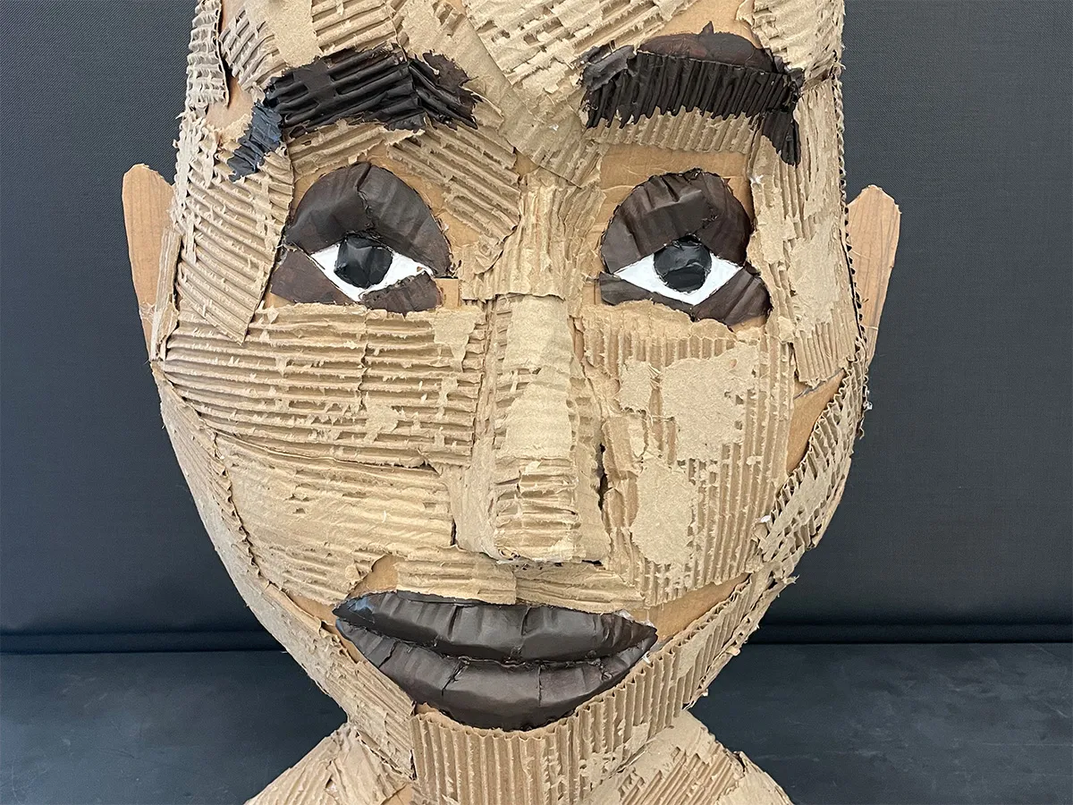 Art exhibit of a man's head made from cardboard
