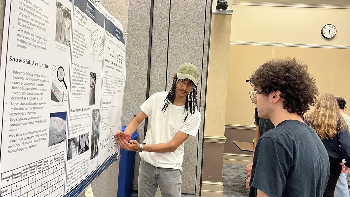 An Honors Program student discusses details of his research during the program's project fair.