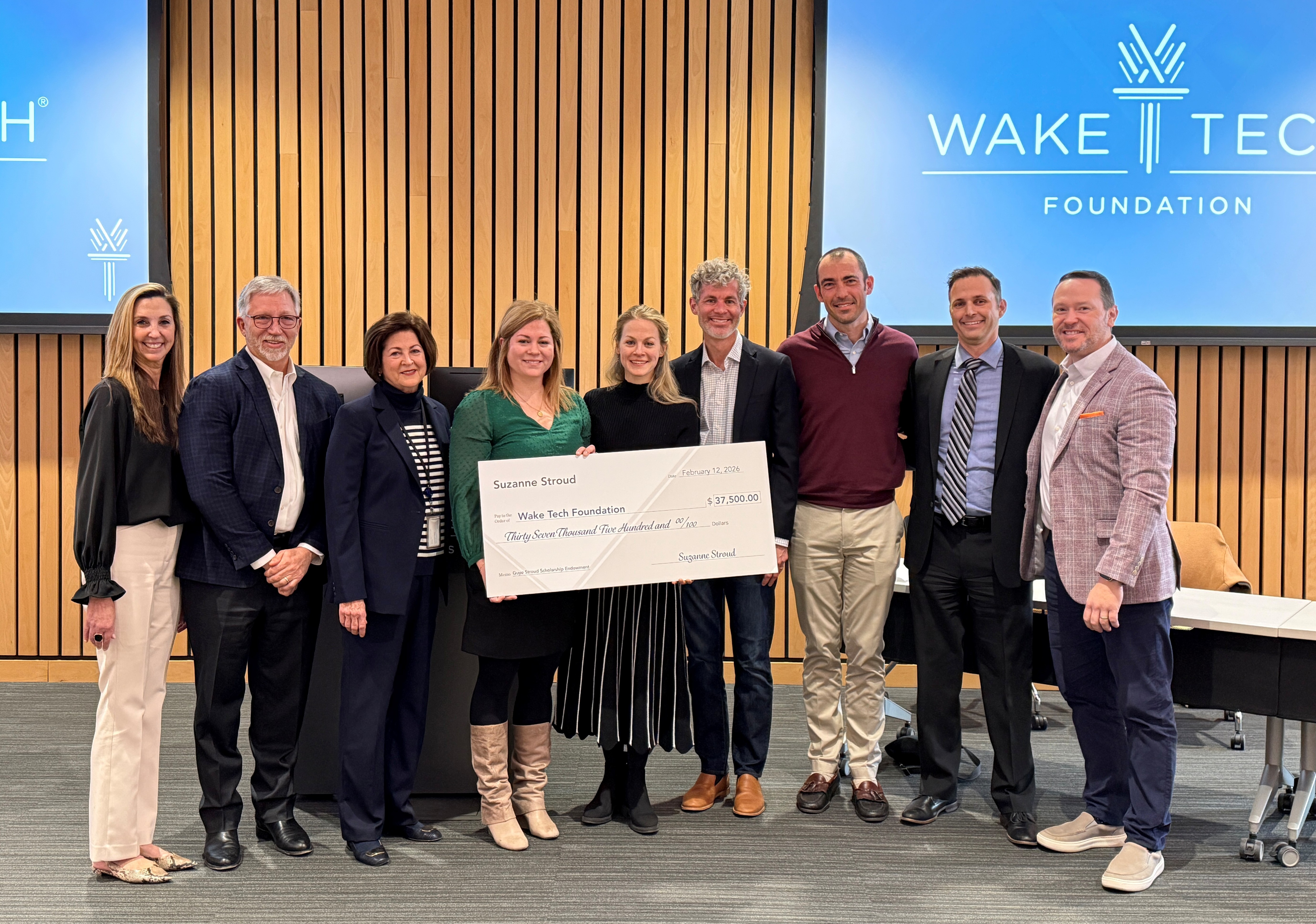 Family of Guye Stroud posing for a photo with a check symbolizing their donation