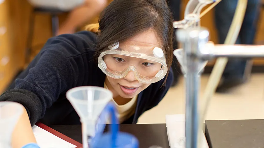 A woman checks on a chemistry experiment.