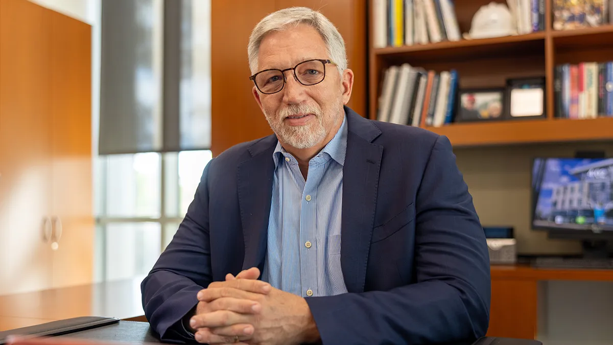 Wake Tech President Dr. Scott Ralls sits at his desk.