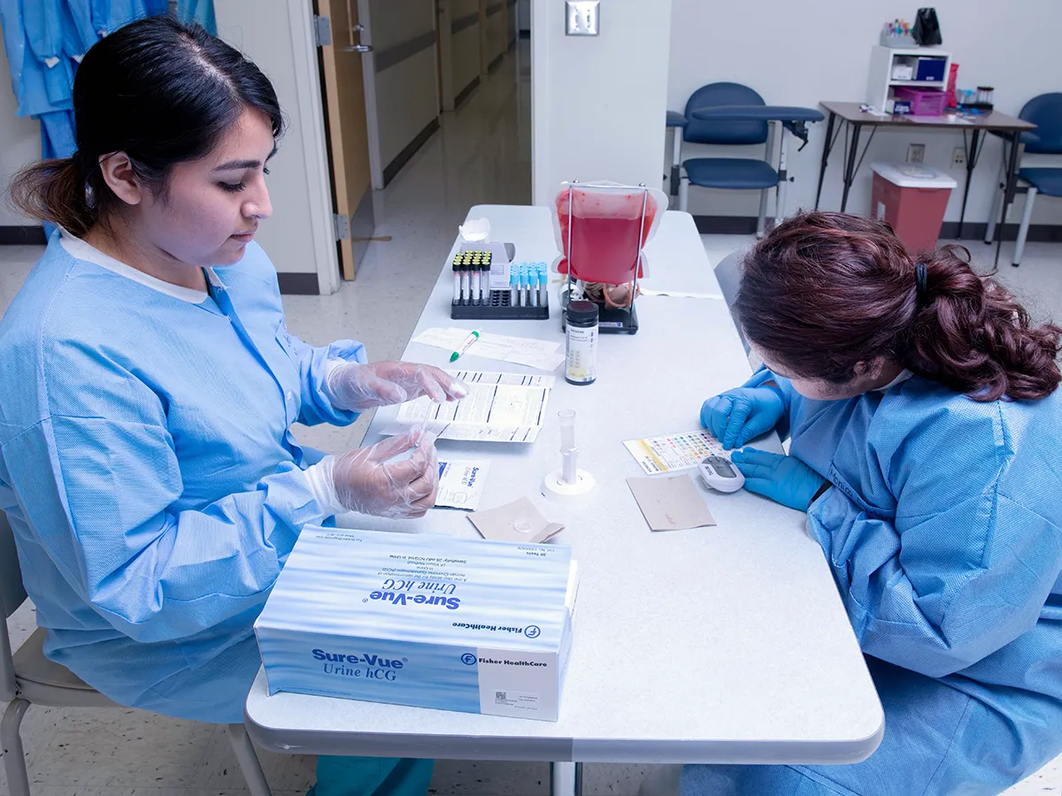 Two Medical Assisting students in training