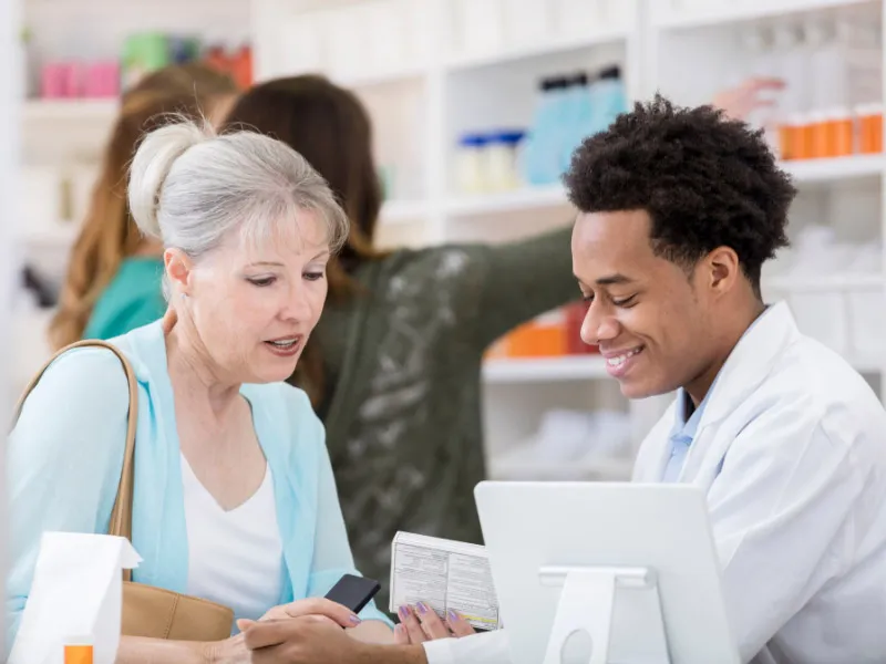 Pharmacy technician consulting with a customer