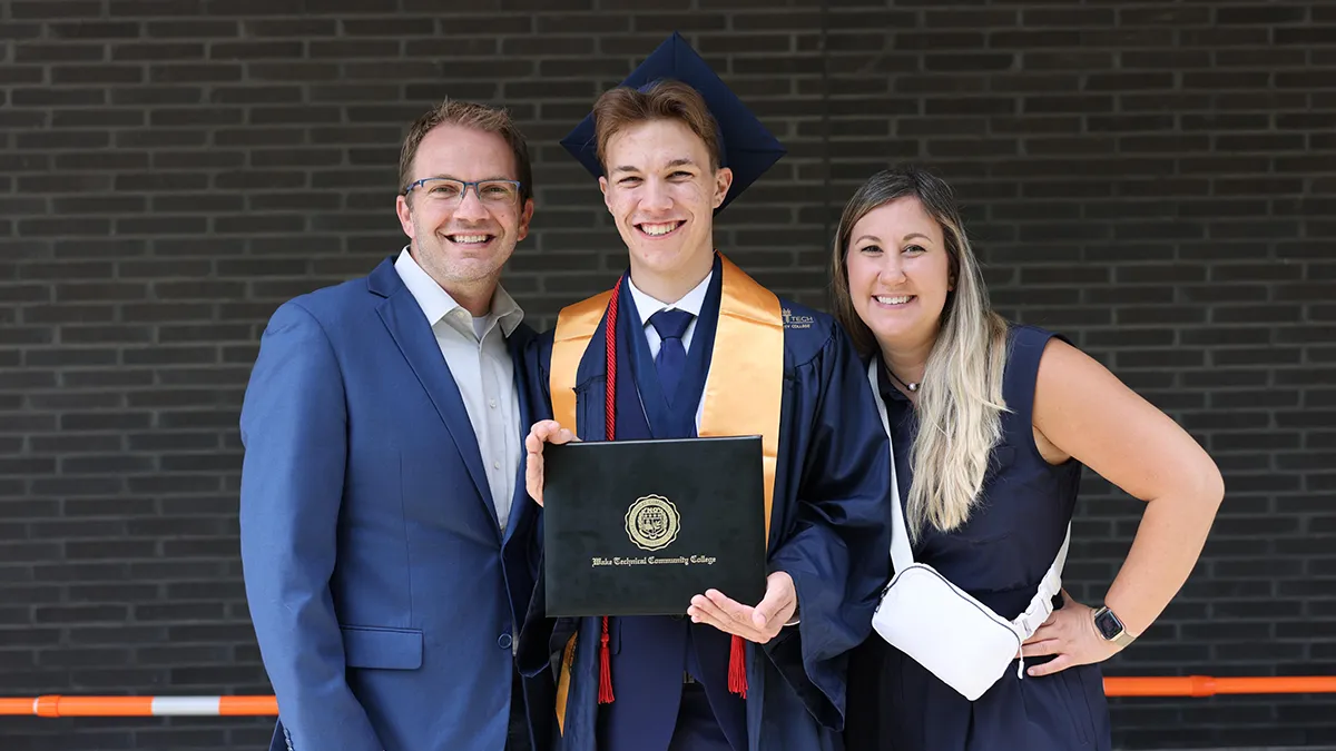 Student Government Association President Silas Johnson poses with his parents after the 2025 Spring Commencement.