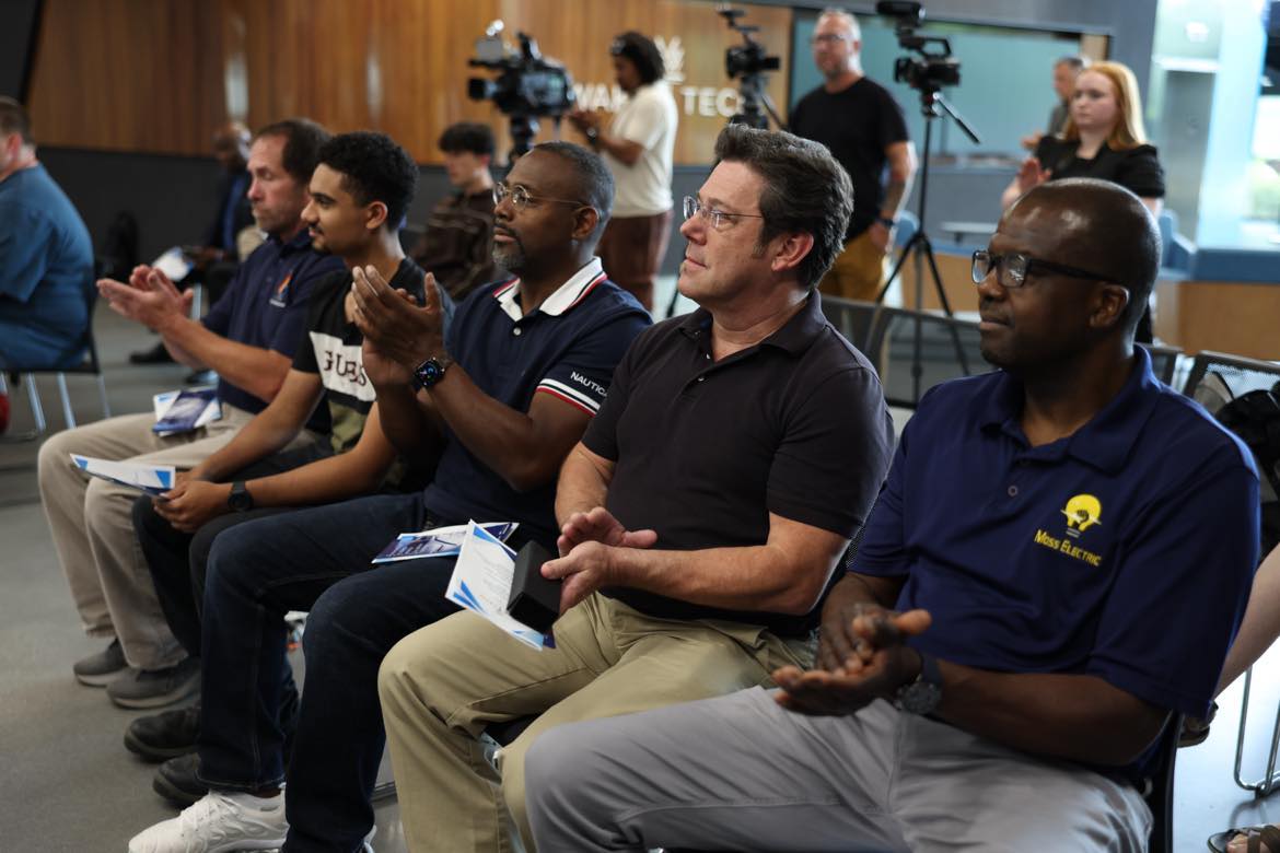 Members of Wake Tech's Electric Vehicle Supply Equipment Field Technician Certification program applaud during a graduation ceremony.