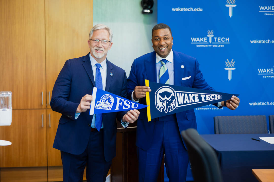 Wake Tech President Dr. Scott Ralls and Fayetteville State University Chancellor Darrell Allison celebrate an agreement to ease credit transfer from Wake Tech to FSU.