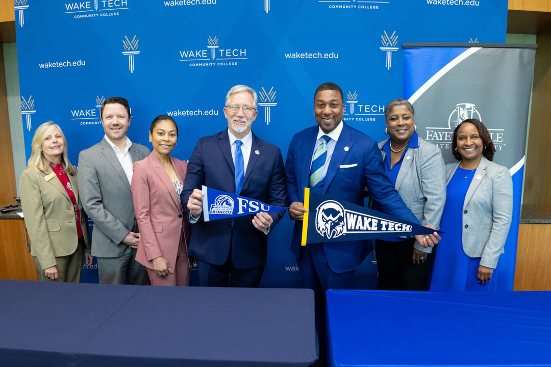 Wake Tech and Fayetteville State University officials celebrate an agreement to ease credit transfer from Wake Tech to FSU.