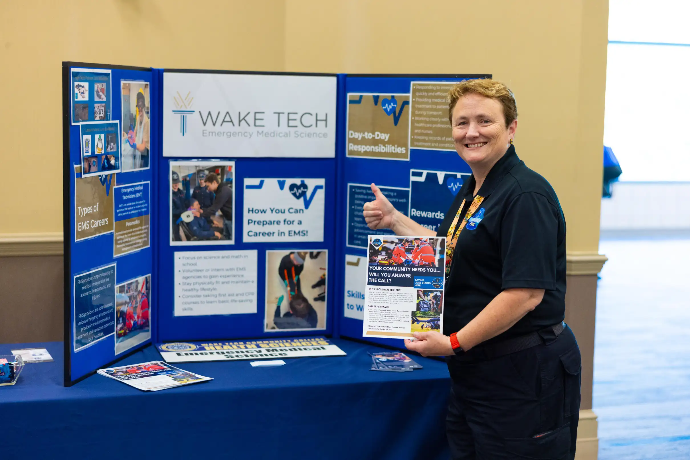 A Wake Tech employees shows off the display for the EMS program at Wake Tech's Job Fair.