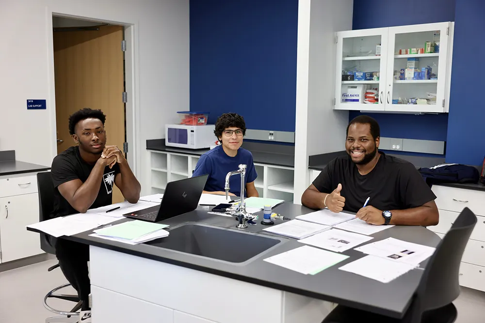Thee Wake Tech students sit in a lab at Wake Tech East on the first day of the 2024-25 academic year.