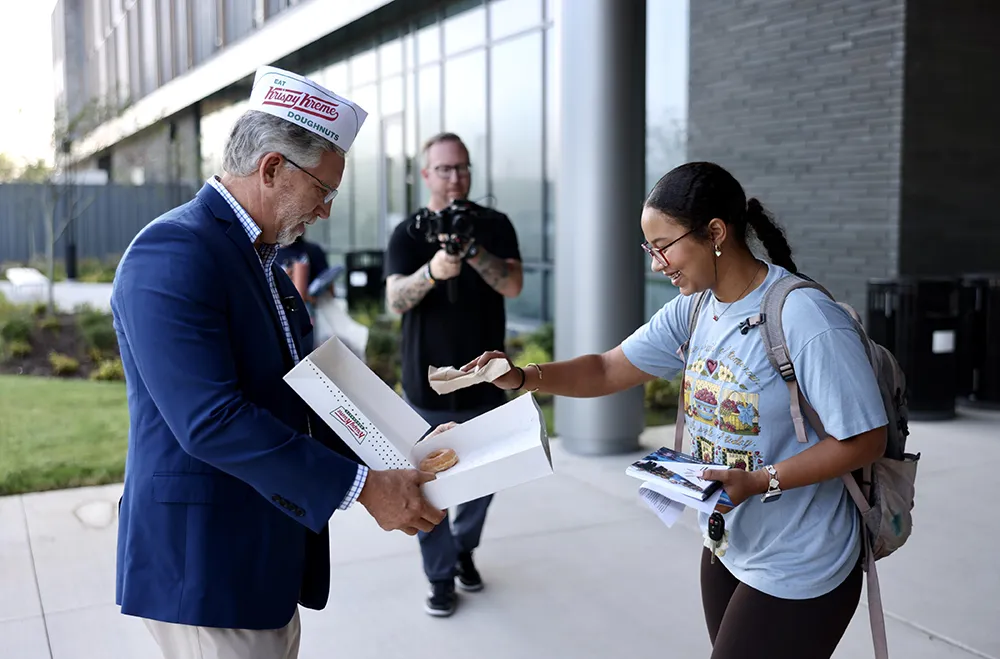 Wake Tech President Dr. Scott Ralls hands out donuts to students on the first day of the 2024-25 academic year.
