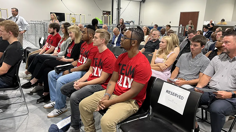 Students and officials attend a ceremony marking the launch of Wake Tech's biomechantronics apprenticeship program.