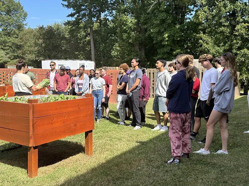 Instructor Lauren Musolf shows Wake Tech students vegetables from the garden on Southern Wake Campus.