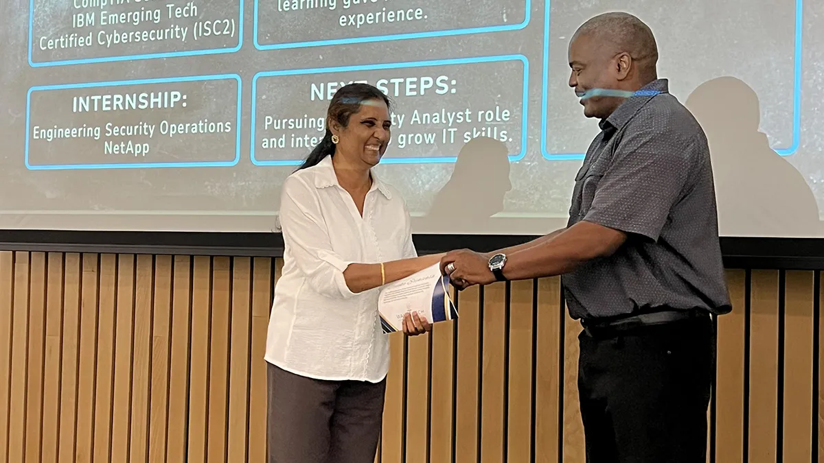 A students is honored during a ceremony for the first cohort to complete the Sentinel Cybersecurity Bootcamp at Wake Tech.