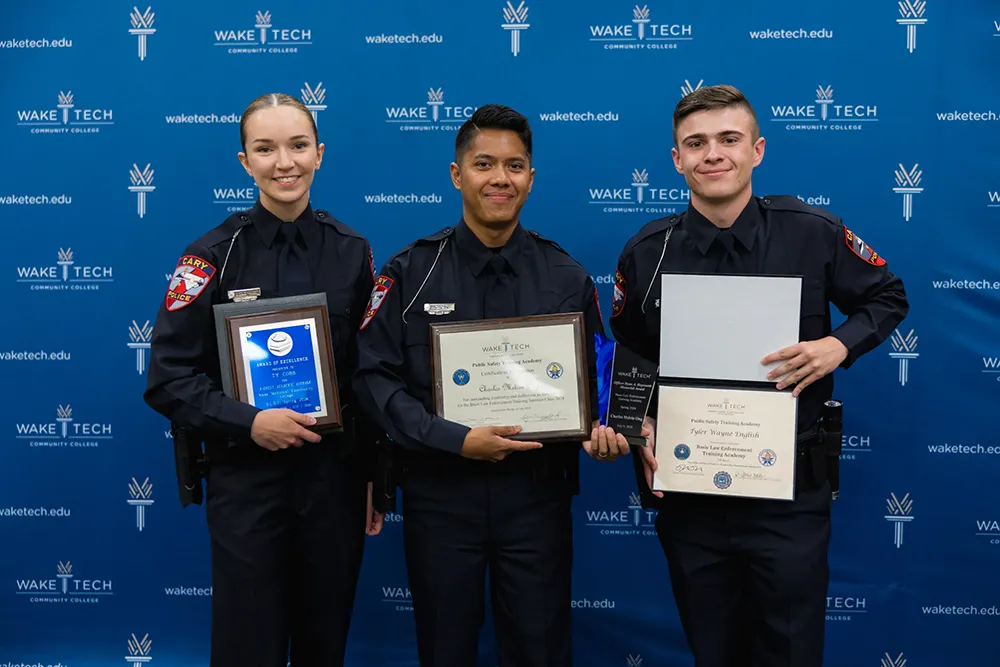 Three members of the latest class to graduate from Wake Tech's Basic Law Enforcement Training Academy pose for a photo.