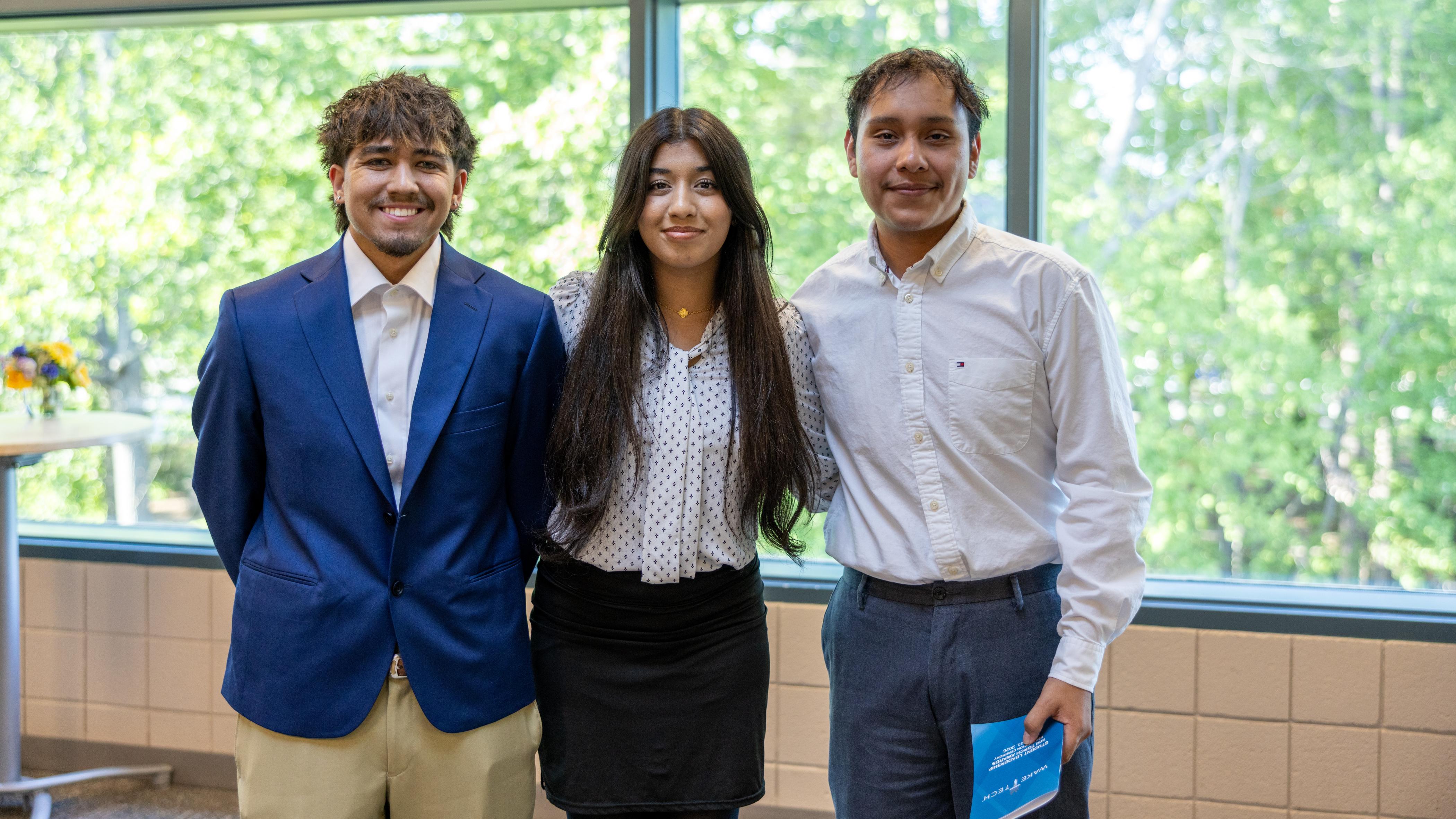 Three student leaders smile after receiving recognition at Student Leadership and Torch Awards ceremony 