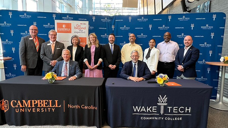 Wake Tech and Campbell University officials celebrate a new transfer partnership agreement.