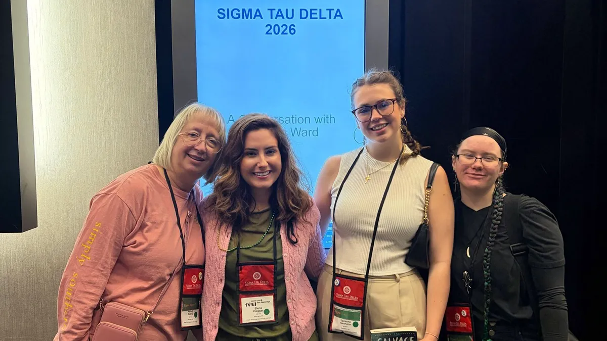 Associate Professor of English Melody Owens, Professor of English Elena Fleggas, students Savanna Hermann and Mae Malhoit, left to right, pose for a photo in front of a 2026 Sigma Tau Delta International Convention sign.
