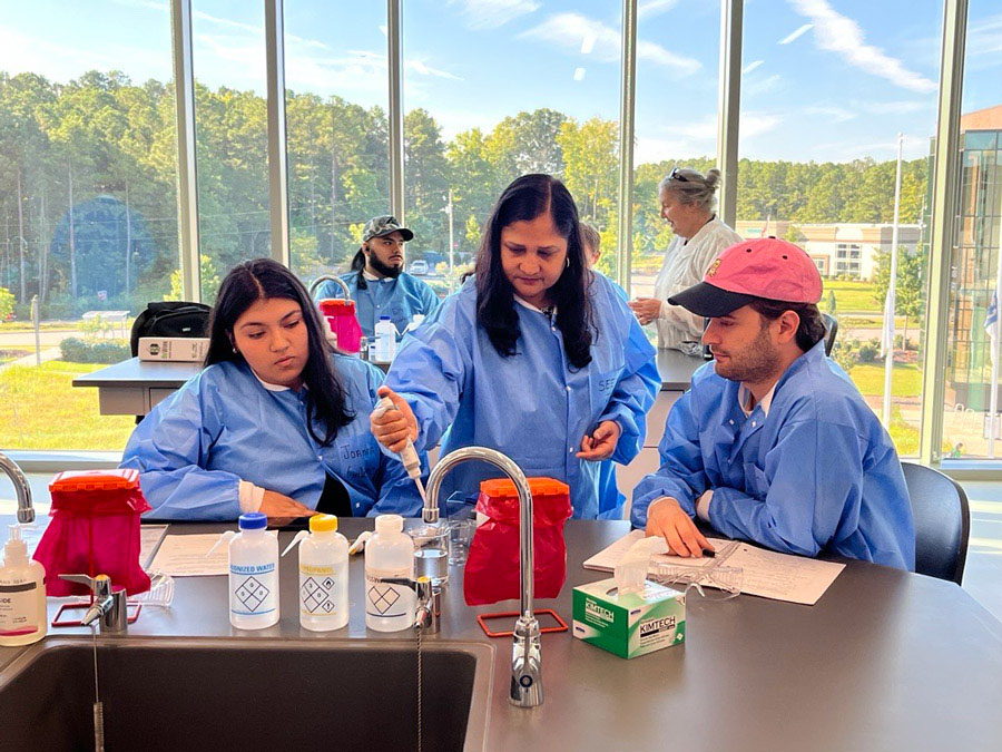 A BioWork instructor demonstrates a process for two students.