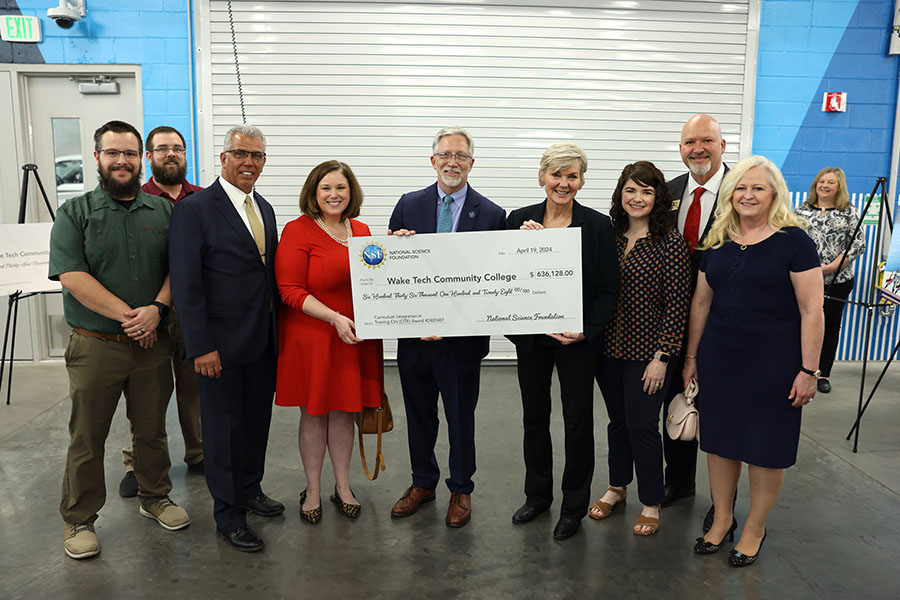 U.S. Energy Secretary Jennifer Granholm presents Wake Tech officials with a check to support training of electric vehicle technicians.