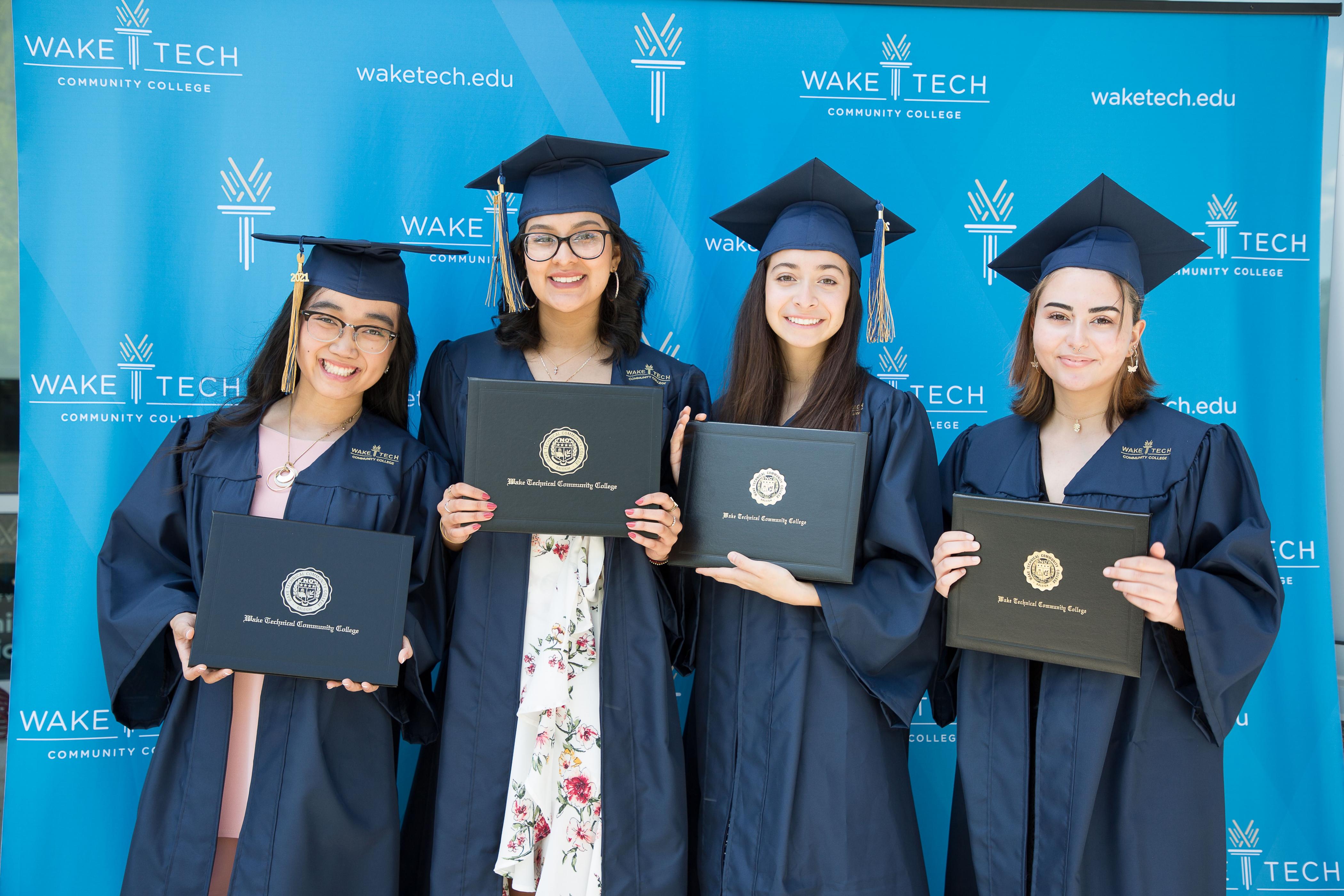 Four Wake Tech graduates proudly display their diplomas