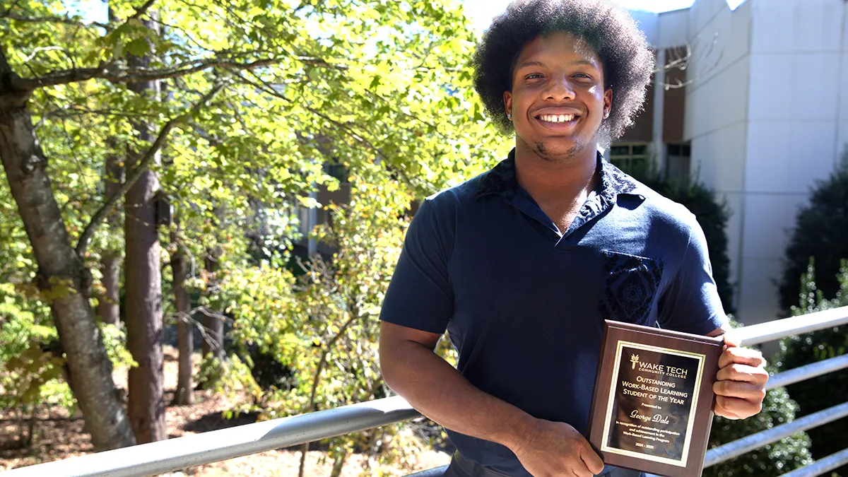 IT Service & Support student George Dale poses with a plaque after being named Wake Tech's 2024-25 Work-Based Learning Student of the Year.