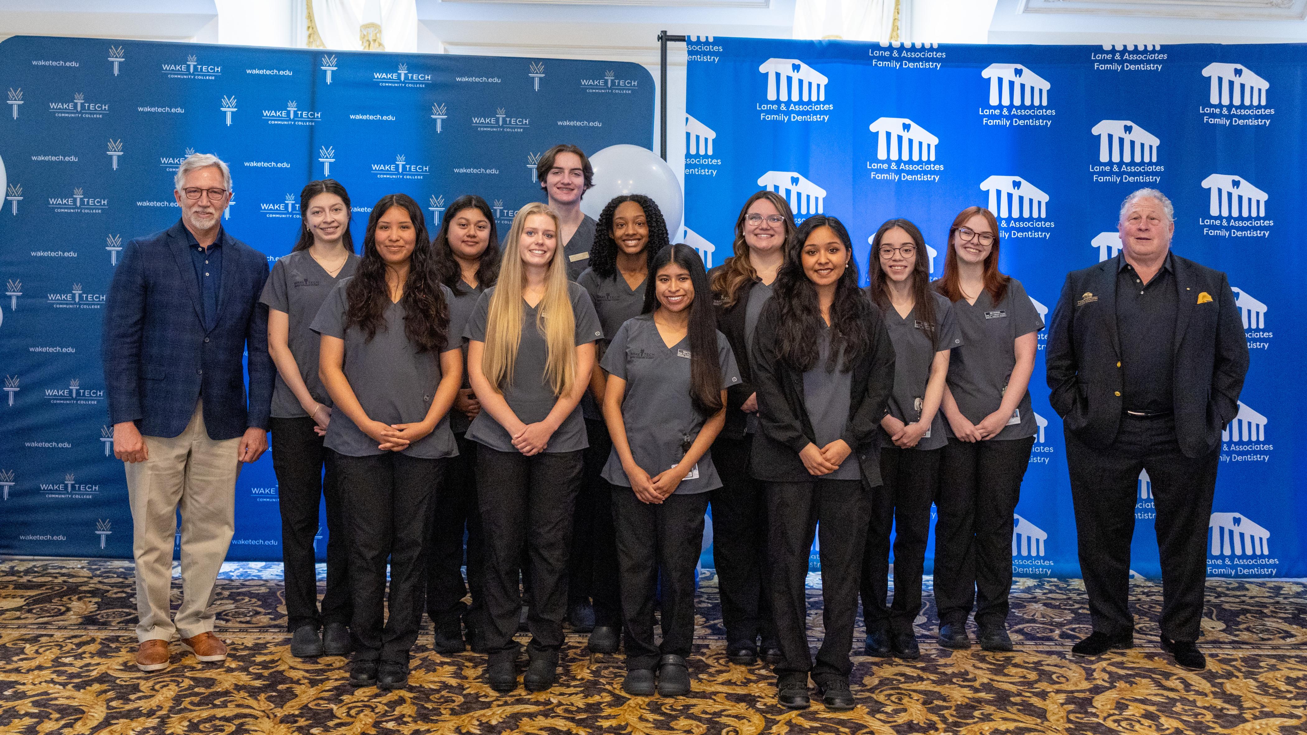Image shows dental assisting apprentices with Wake Tech President Dr. Scott Ralls and Dr. Don Lane, Founder of Lane & Associates Family Dentistry.