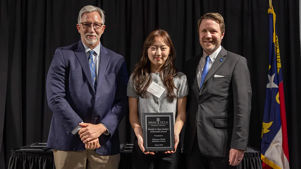 Wake Tech President Dr. Scott Ralls and Vice President Brian Gann pose for a photo with student Sehyun Park.