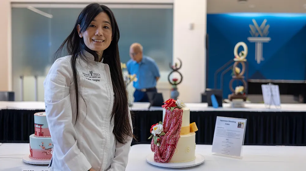 Wake Tech Baking & Pastry Arts student Yukie Signini poses with her Japanese Wedding Cake creation, which earned top honors at the North Carolina American Culinary Federation competition.