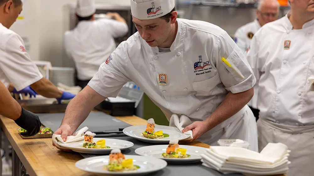Members of Culinary Team USA prepare dishes for a fundraising dinner at Wake Tech that will help pay for expenses during the team's trip to Germany for the 2028 Culinary Olympics.