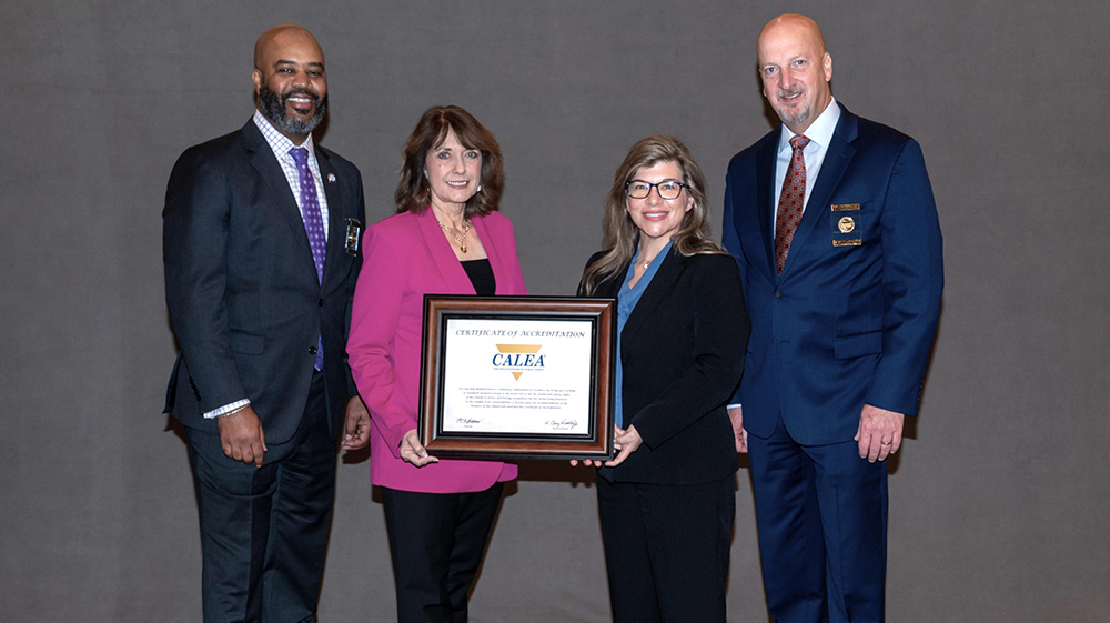Wake Tech and CALEA staff pose with college's accreditation certificate