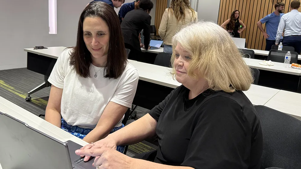 A Wake Tech student points to laptop during a cybersecurity workshop.