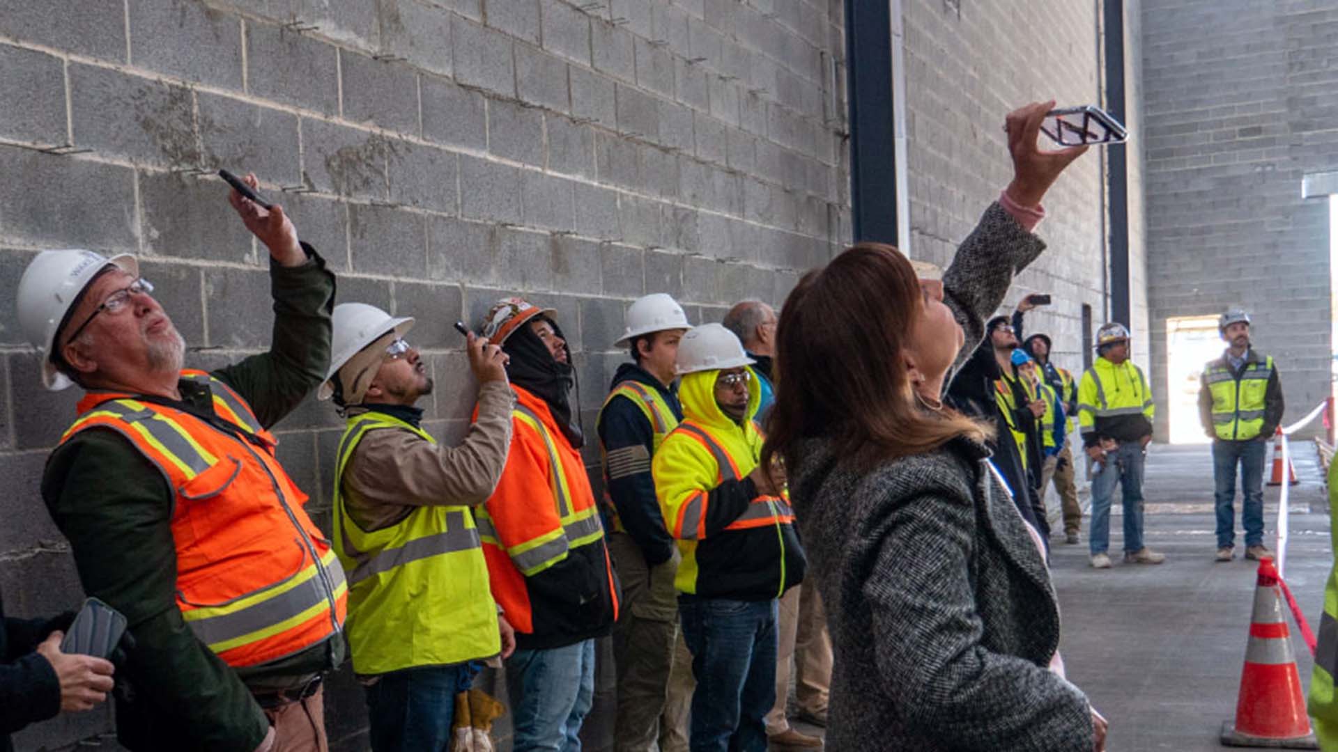 Wake Tech staff and construction workers take photos during topping-out ceremony