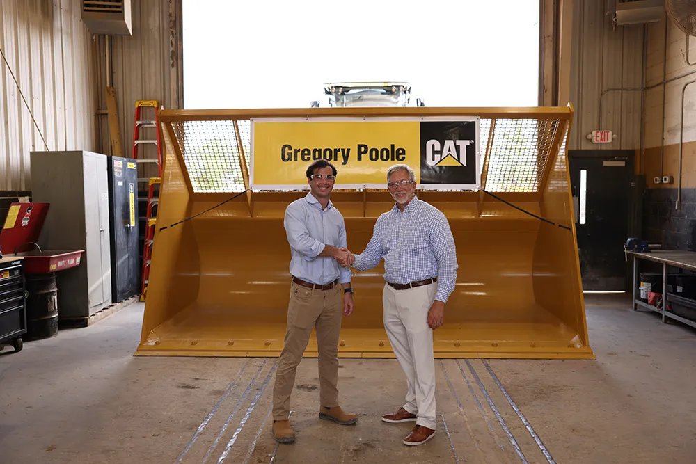 Wake Tech President Dr. Scott Ralls, right, and Greg Poole IV shake hands after announcing an apprenticeship program between the college and Gregory Poole Equipment Company.