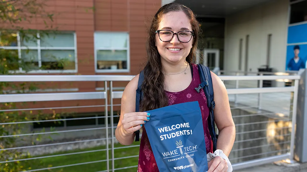 A Wake Tech student displays a welcome packet faculty and staff handed out to students on the first day of the 2025-26 school year.