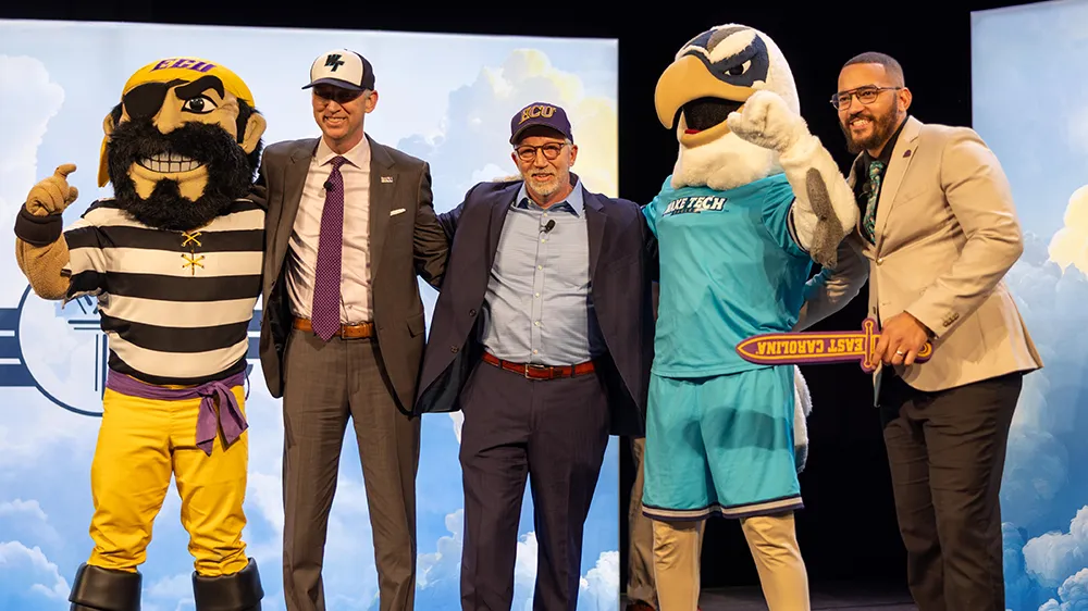 East Carolina University Chancellor Dr. Philip Rogers, Wake Tech President Dr. Scott Ralls and Wake Tech graduate Jose Fabre Jr. pose with the mascots for both schools.
