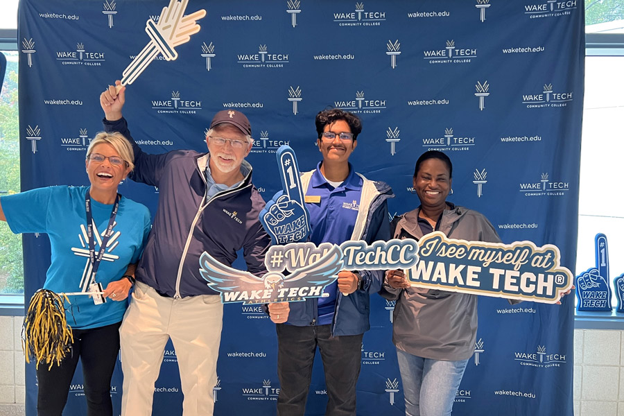 Wake Tech staff and students pose with college signs at Open House
