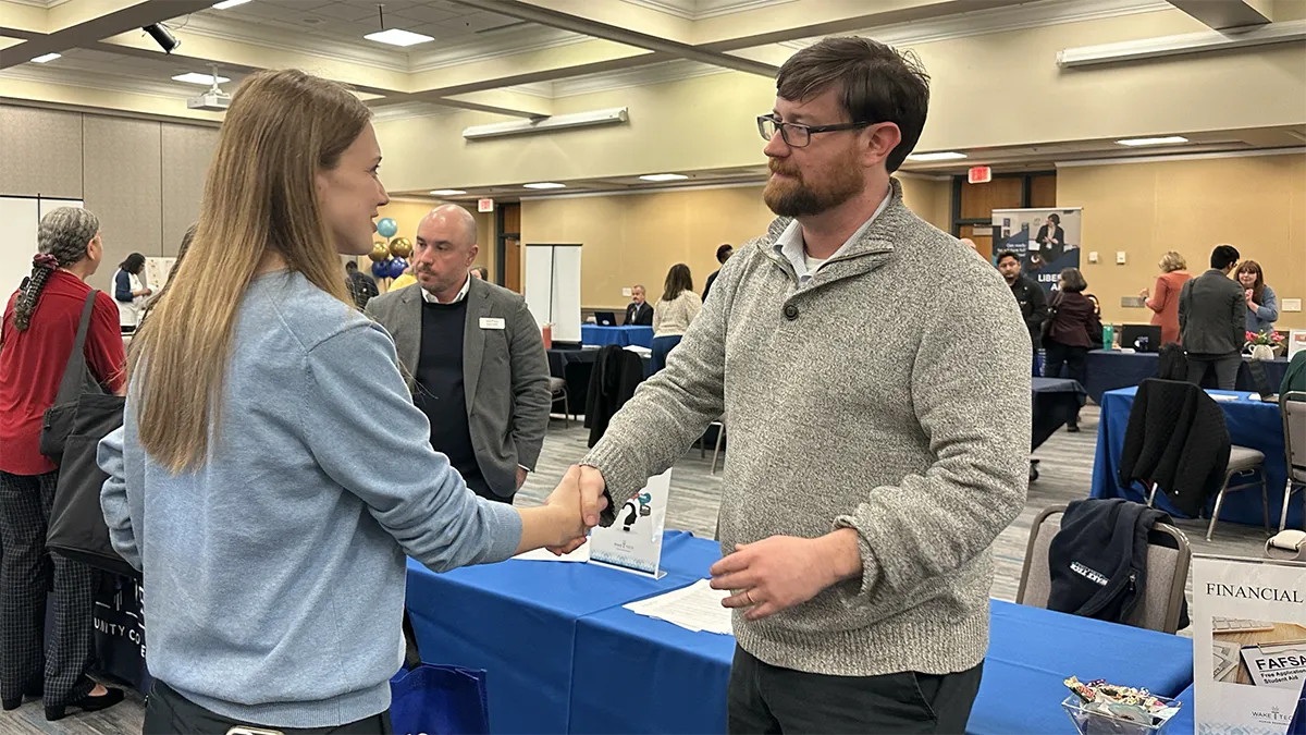 A man and a woman shake hands during a Wake Tech Job Fair.