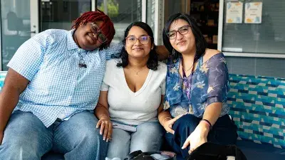 Three Wake Tech students gather at a table.