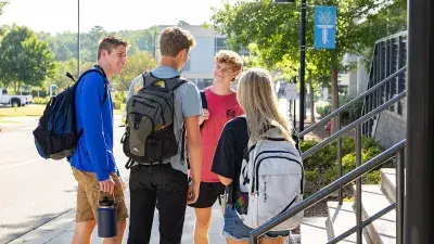 Three Wake Tech students gather at a table.