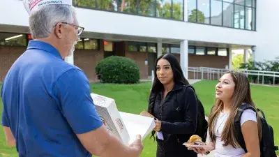 Three Wake Tech students gather at a table.