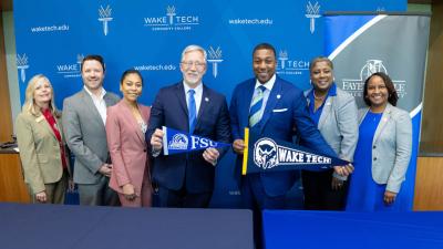 Wake Tech President Dr. Scott Ralls, left, and Fayetteville State University Chancellor Darrell Allison shake hands after signing a transfer agreement.