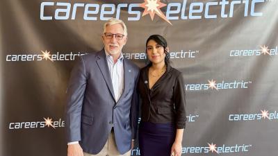 Wake Tech graduate Pilar Andrande-Rosalino standing in front of circuitry