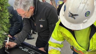 College Holds Topping-Out Ceremony for First Building at Future Campus