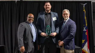 A table filled with trophies and plaques for Wake Tech Excellence Award winners