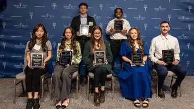 A table filled with trophies and plaques for Wake Tech Excellence Award winners