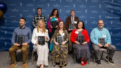 A table filled with trophies and plaques for Wake Tech Excellence Award winners
