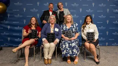 A table filled with trophies and plaques for Wake Tech Excellence Award winners